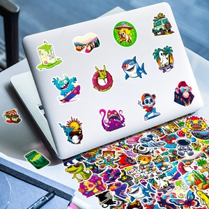 Close-up of waterproof vinyl street art stickers on a silver laptop and scattered pile