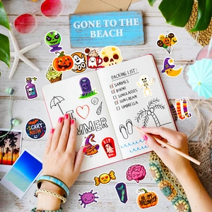 Flat lay of colorful Halloween and summer stickers on a desk with beach themed props