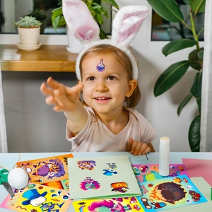 Young girl creating Halloween crafts with spooky stickers and DIY tools at home