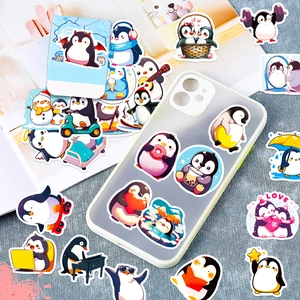 Cute cartoon penguin stickers applied to a clear phone case and spread on grey fabric