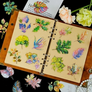 Detalle de pegatinas de hojas doradas con láser en cuaderno de cuero vintage
