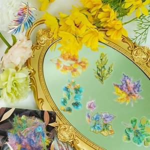 Detalle de pegatinas de hojas doradas holográficas en un espejo vintage para manualidades