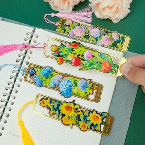 Detail of hollow brass bookmarks with colorful floral designs and matching tassels