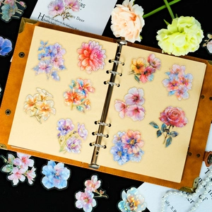 Macro detail of floral PET stickers with gold foil on a vintage leather journal
