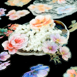 Macro detail of floral PET stickers with gold foil accents on decorative glass tray