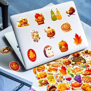 Macro shot of colorful Thanksgiving turkey and pumpkin stickers on a laptop lid