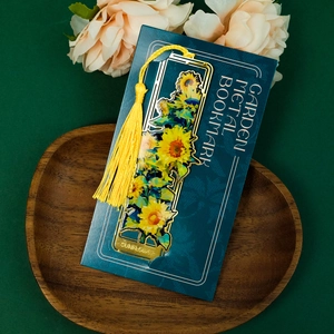 Detail view of brass sunflower bookmark with yellow tassel on display card
