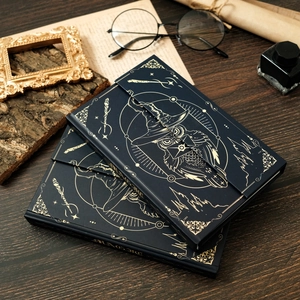 Vintage magic owl notebook with gold foil wizard pattern and elastic strap on wood