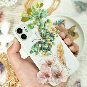 Detalle de pegatinas PET con lámina dorada en una funda blanca sostenida a mano