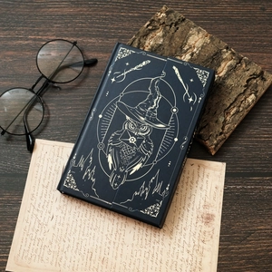 Close-up of magic owl notebook with gold foil stamping on a vintage wooden desk