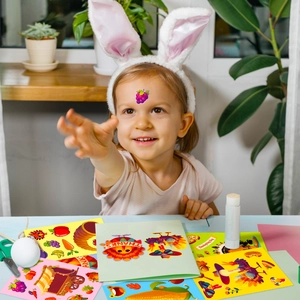 Detail of a child playing with Thanksgiving themed turkey and pumpkin DIY stickers