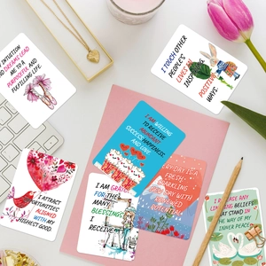 Flat lay of colorful hand-drawn inspirational quote cards on a desk with pink tulips