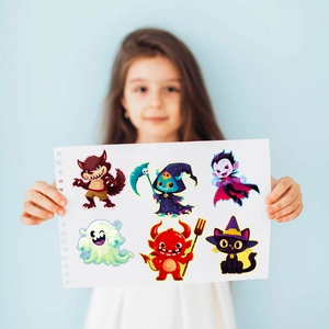 Gros plan de 6 sets d'autocollants d'Halloween pour enfants tenus par une main