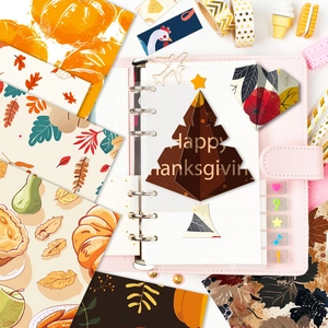 Plano cenital de papel de scrapbooking de calabaza y arce en una carpeta rosa