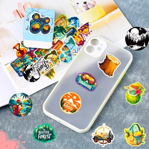 Outdoor adventure stickers set featuring mountains and camping scenes on a notebook