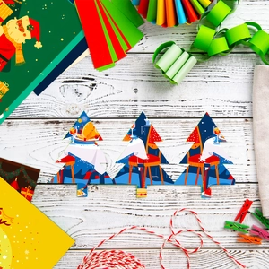 Flat lay of Christmas tree shaped paper cutouts with festive dining illustrations on wood