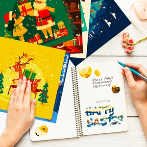 Flat lay of vintage Christmas scrapbook paper kit with festive illustrations and stickers
