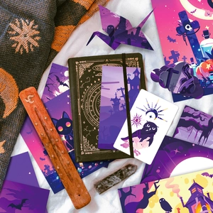 Set de papelería de Halloween con cuaderno negro y tarjetas moradas sobre seda blanca