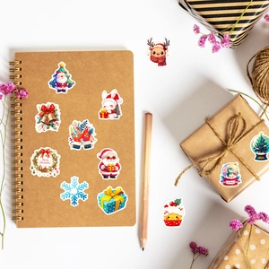 Detailansicht bunter Weihnachtsaufkleber auf Geschenkpapier aus Kraftpapier und Notizbuch