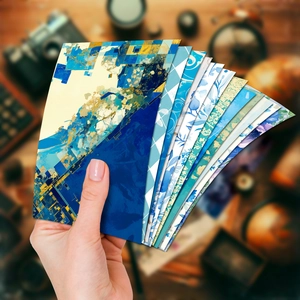 Detailed close-up of blue floral decorative scrapbook paper held in hand fan style