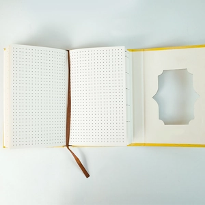 Détail du carnet à couverture rigide jaune avec pages à pointillés et fenêtre fleurie