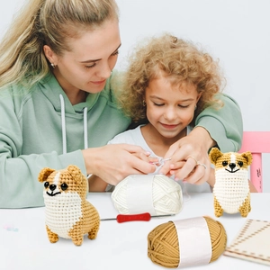Detail van corgi haakpakket met garen, gereedschap en afgewerkte knuffel in de hand