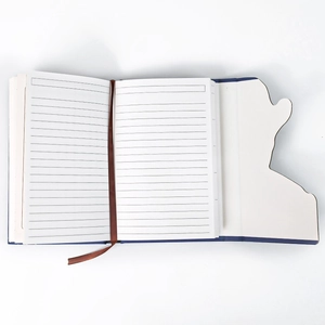 Detail view of Van Gogh notebook featuring ruled cream paper and a silk ribbon bookmark
