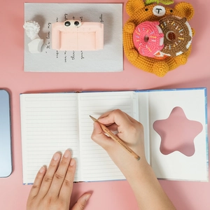 Flat lay of open notebook with star cutout cover showing lined paper and handwriting
