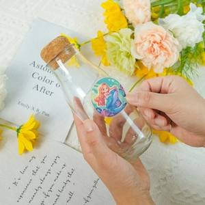 DIY mermaid princess stickers on a mini glass bottle with floral decorative background