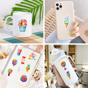 Detail showing waterproof dessert stickers applied on a mug, phone case, and notebook