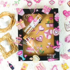 Macro view of transparent Valentine stickers with glass cork vials and gold frame