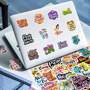 Diverse kleurrijke Engelse motiverende graffiti stickers op een witte laptop geplakt