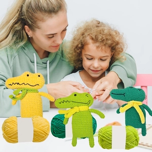 Three colorful crochet crocodiles and yarn balls with mother and daughter crafting