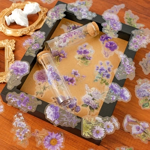 Detailed macro view of purple floral PET stickers on a vintage wooden desk background