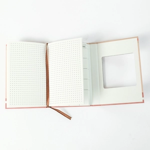 Detail of pink hardback notebook with dot grid pages and brown ribbon bookmark