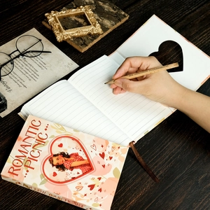 Vintage Romantic Picnic pink hardcover notebook with pencil on a rustic wooden desk
