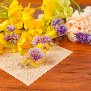 Detail of purple lily and lavender PET flower stickers on vintage paper over wooden desk