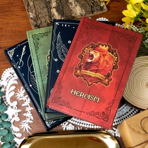 Detail of magic totem hardcover notebooks with gold foil hero motifs and retro texture