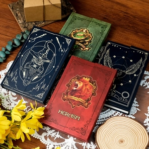 Macro view of four magic academy notebooks with gold foiled crests and elastic bands
