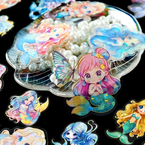Charming laser holographic mermaid stickers with gold foil edges on a decorative shell tray