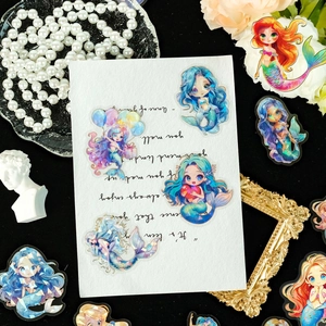 Detailed holographic mermaid stickers with gold foil accents on decorative background