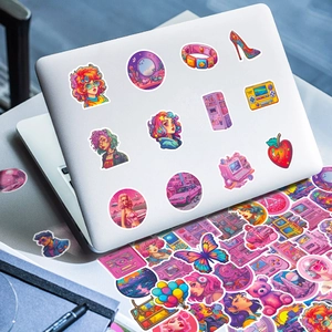 Macro view of pink and purple Y2K stickers applied to a silver laptop surface