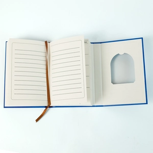 Blue hardcover notebook featuring dotted lined pages, brown silk bookmark, and die-cut window