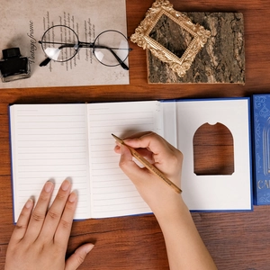 Detailed view of dark blue hardcover notebook with arched cutout window and lined pages