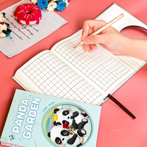 Close-up of Panda Garden grid notebook featuring a light blue cover and cute panda illustration