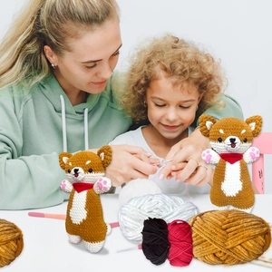 Close-up of handmade crochet shiba inu dolls with yarn balls and diy knitting tools