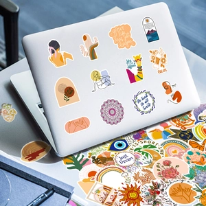 Boho style waterproof stickers applied on a white laptop with various colorful patterns