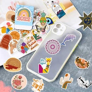 Detail view of colorful Boho stickers applied on phone case and scattered stationery items