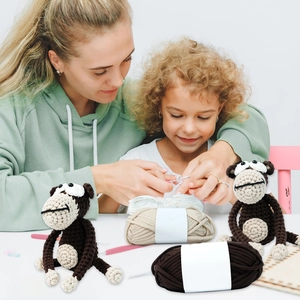 DIY crochet kit for gorilla doll featuring thick yarn rolls and finished handmade figures