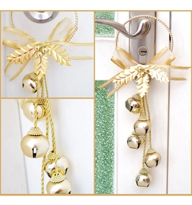 Detalle de campanas navideñas doradas con hojas metálicas y un lazo de organza elegante
